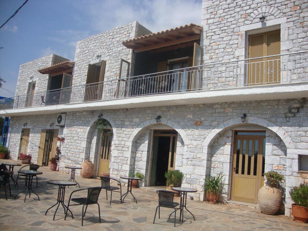 een patio met tafels en stoelen voor een gebouw bij Kafiona Guesthouse in Pirgos Dhirou