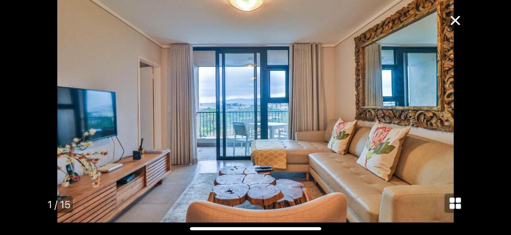 a living room with a couch and a tv at Waters Edge Sanctuary in Cape Town