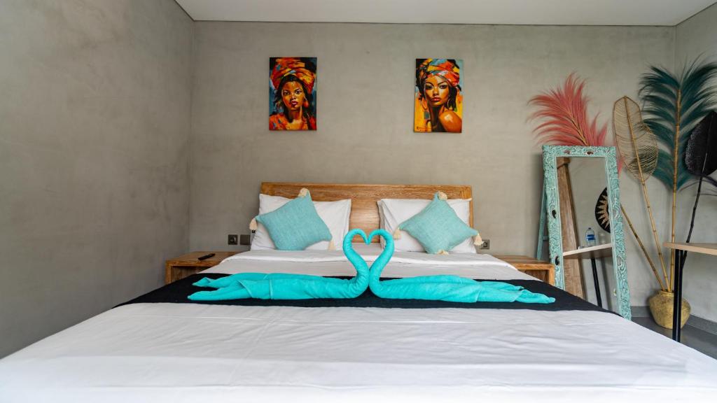 a bedroom with a bed with two swans on it at Villa Alam Kita in Ubud