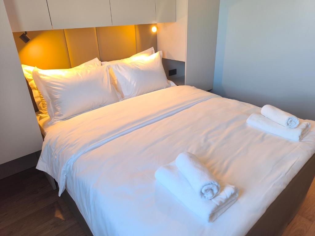 a large white bed with two towels on it at Amadria Exclusive Beach Villa in Šibenik