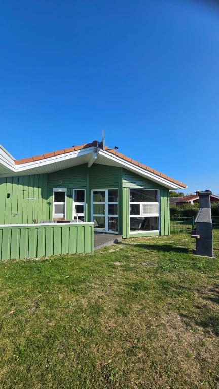 a green house with a yard in front of it at Kapitänshus-Strandpark 24 in Grömitz