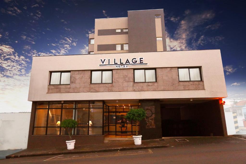 un edificio con un cartello che legge "Village Hotel" di Village Hotel a Ponta Grossa