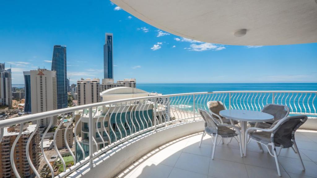 einen Balkon mit einem Tisch, Stühlen und Meerblick in der Unterkunft Aegean Resort Apartments in Gold Coast