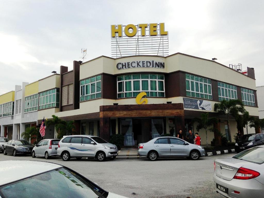 a hotel with cars parked in front of it at Hotel CheckedInn in Ipoh