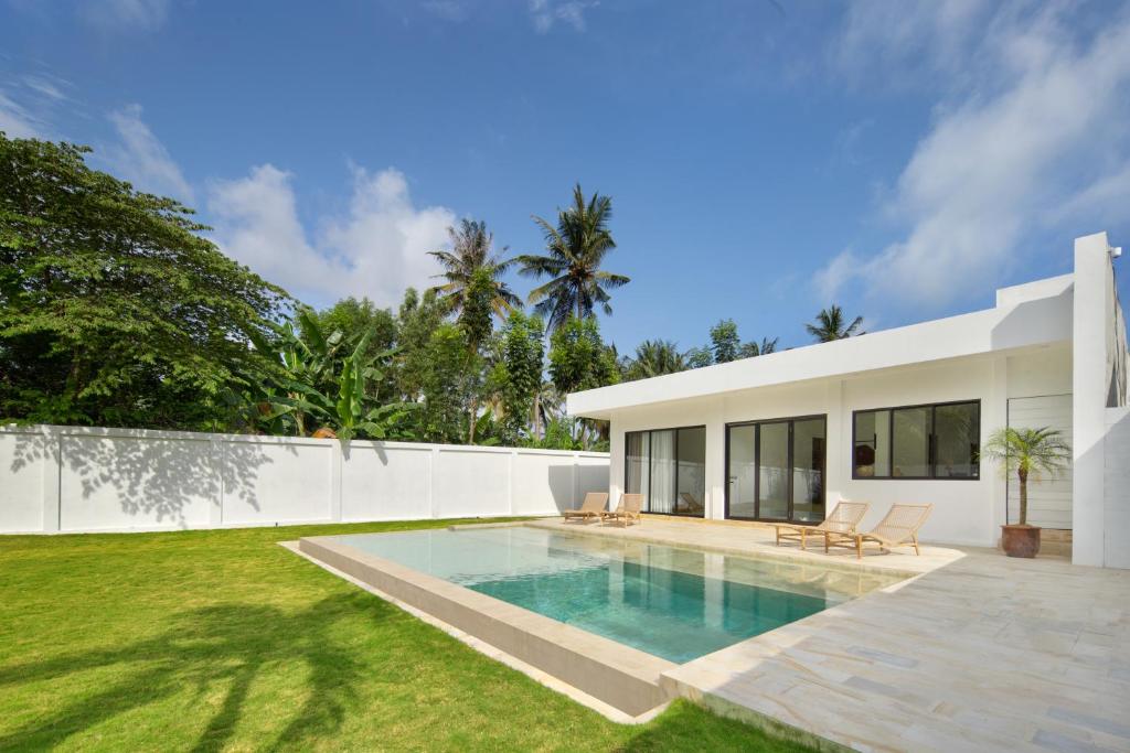 a swimming pool in the backyard of a house at Balear Villa in Kuta Lombok