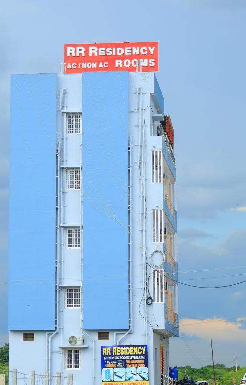 a white building with a sign on top of it at RR Residency in Vishāram
