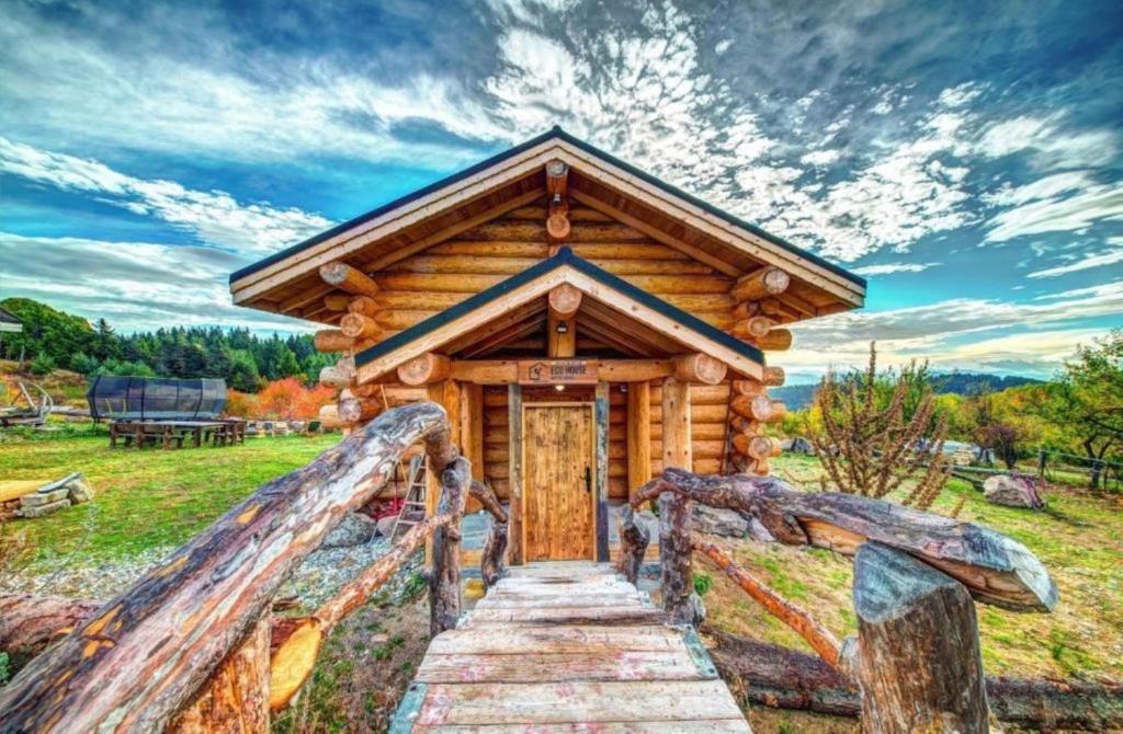 Cabaña de madera con escalera que conduce a una puerta en ECO HOUSES ART OF LIVING - Еко къщи изкуството да живееш, en Pamporovo