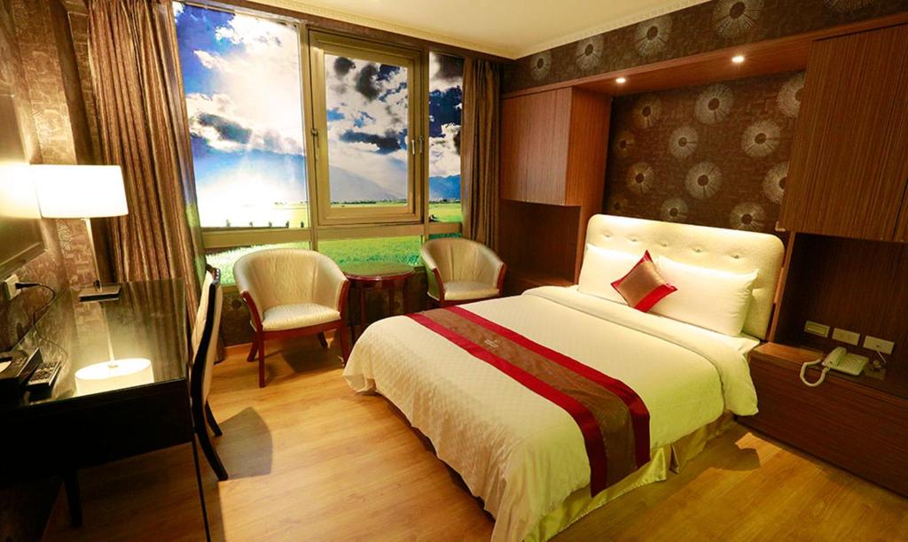 a bedroom with a bed and a desk and windows at Wonderful Hall Hotel in Xinzhuang