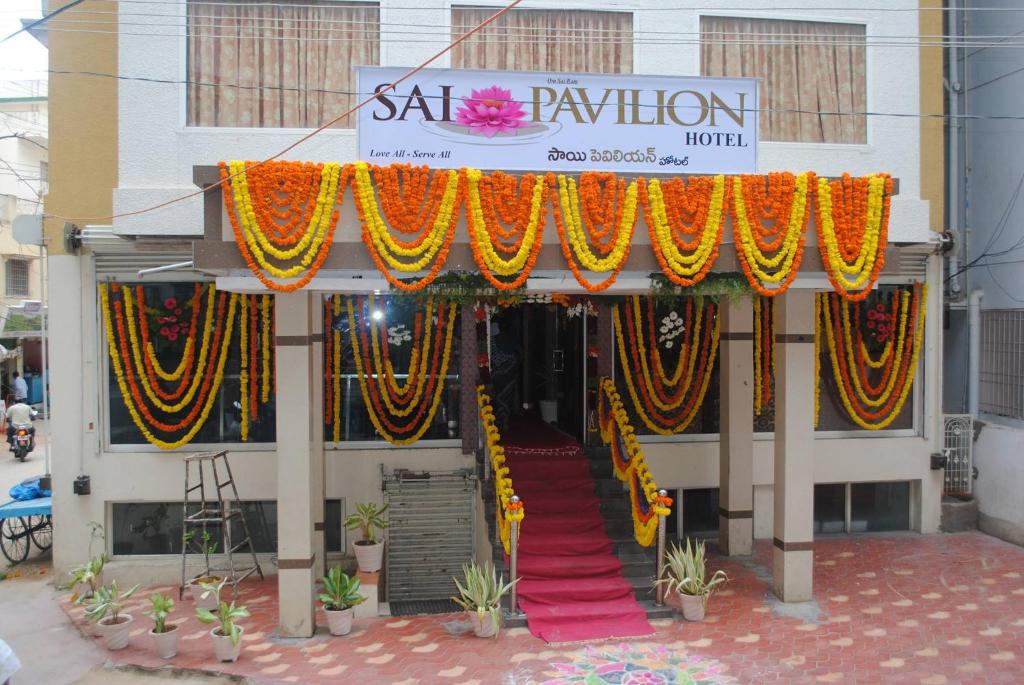 uma frente de loja com um tapete vermelho e cortinas coloridas em Sai Pavilion em Puttaparthi