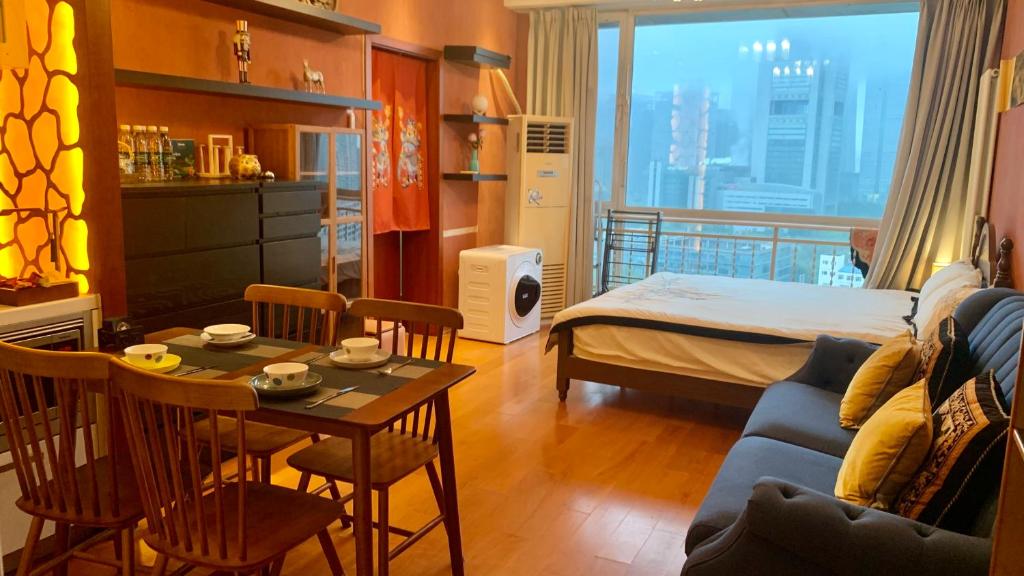ein Wohnzimmer mit einem Bett und einem Tisch mit Stühlen in der Unterkunft Beijing City center - One bedroom flat with two beds and CBD view in Peking