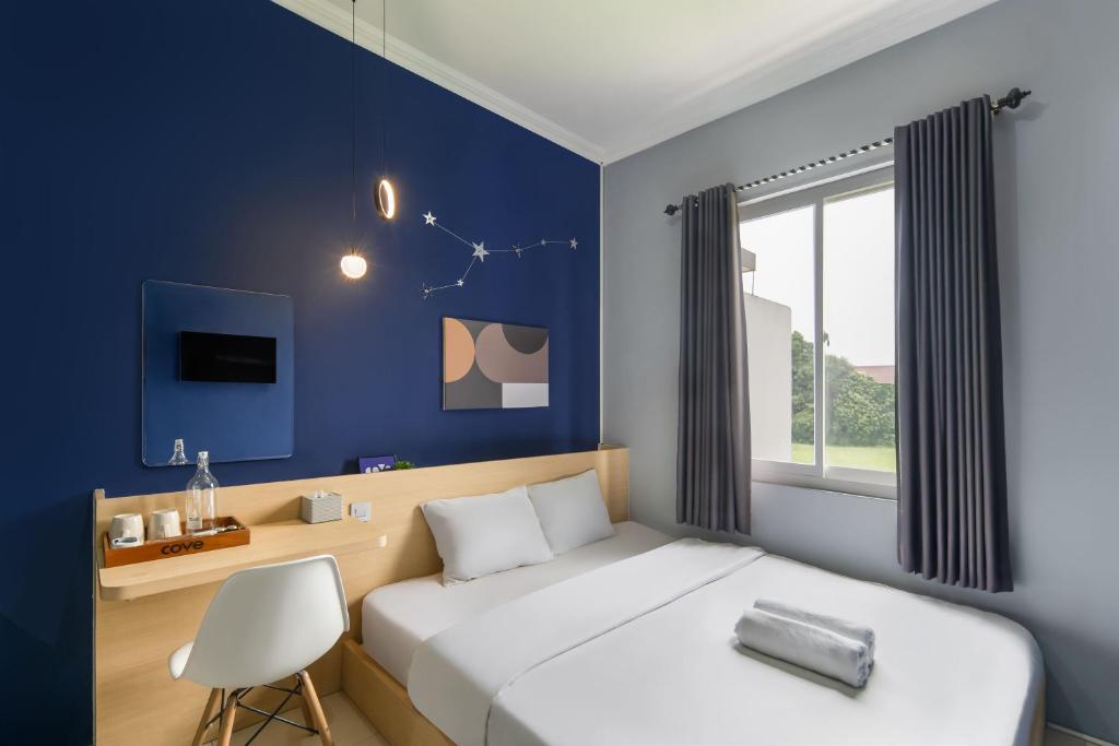 a bedroom with a white bed and a blue wall at Cove Stariez in Binong