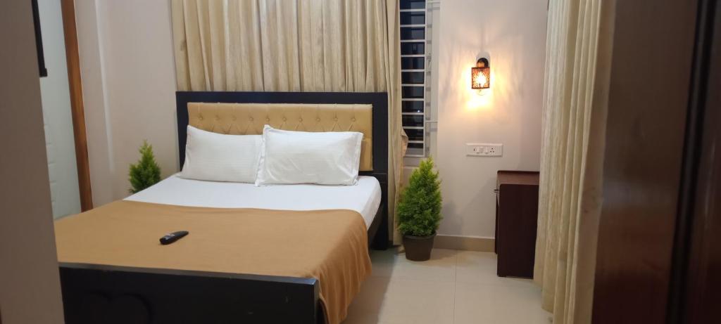 1 dormitorio con 1 cama con mando a distancia en Dream Palace Kodaikanal, en Kodaikanal