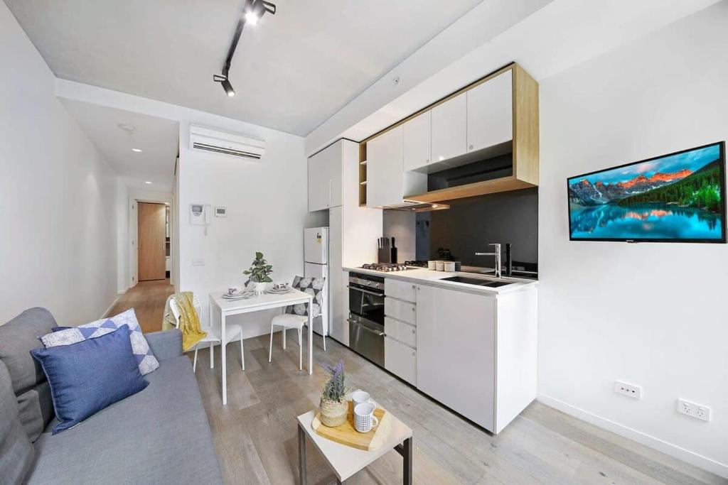 a room with a kitchen and a living room at Bright & Modern 2BR Apt Walk to Central in Melbourne