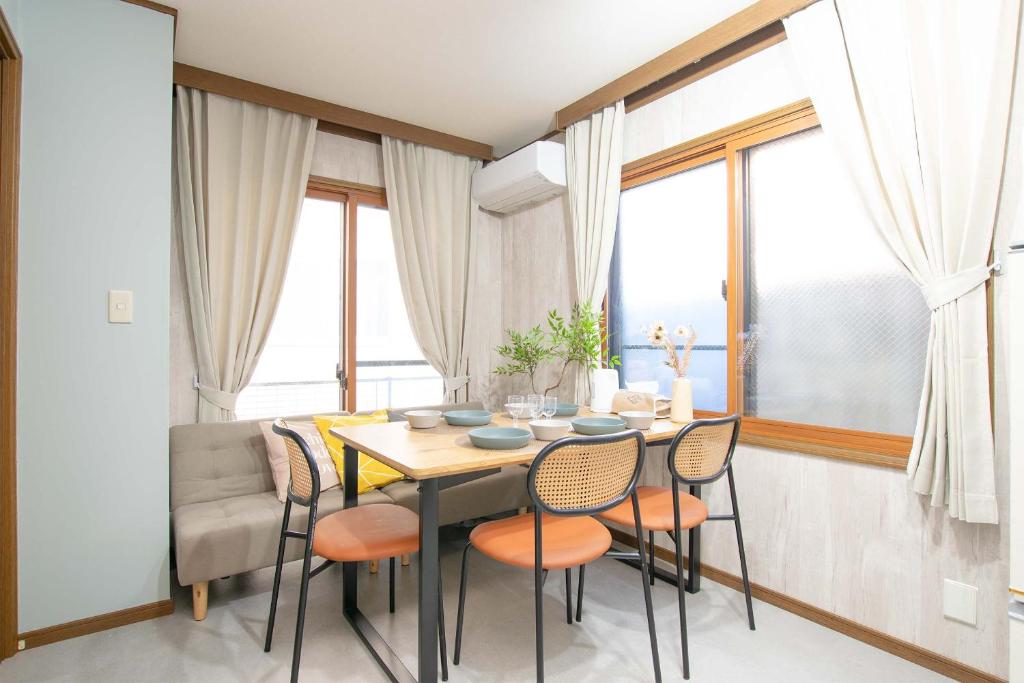 a dining room with a table and chairs and windows at ever Inn Asagaya in Tokyo