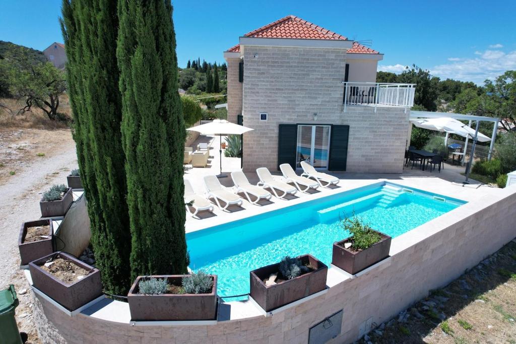 a swimming pool in front of a house at Villa Allegra w Private Pool in Škrip