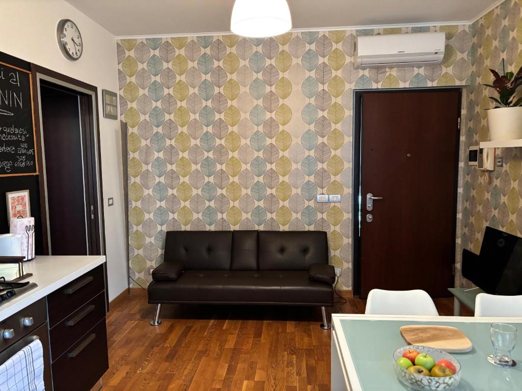 a living room with a black couch in a kitchen at Bumbunin in Alba