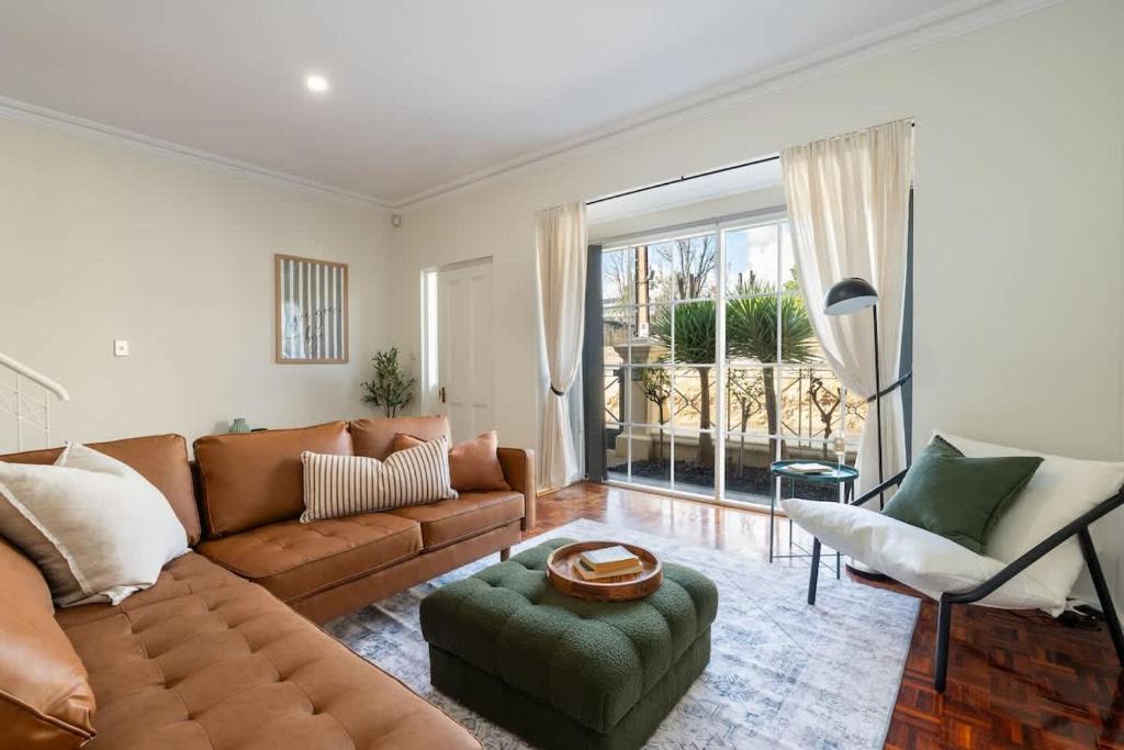 ein Wohnzimmer mit einer Couch und einem Sessel in der Unterkunft 3 Bed Close To City Adelaide Oval Golf Course in North Adelaide