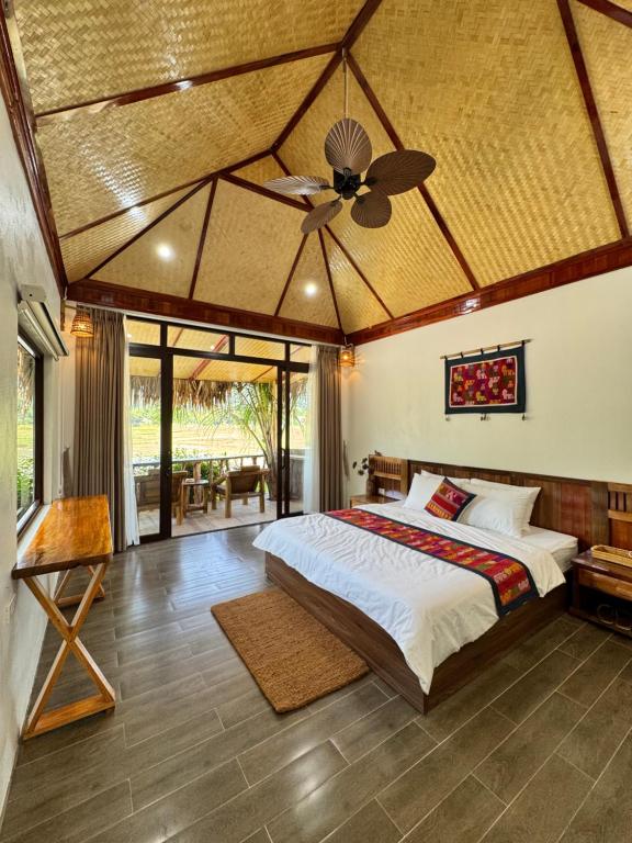 ein Schlafzimmer mit einem Bett und einem Deckenventilator in der Unterkunft Coconut Minh Tho Homestay in Mai Châu