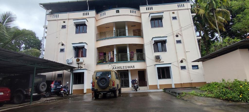 a building with a vehicle parked in front of it at Vedic Nirvana Home Stays & Rooms in Irinjālakuda
