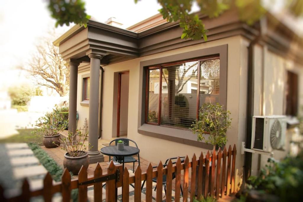 a small house with a table and a fence at Pine & Pebble in Centurion