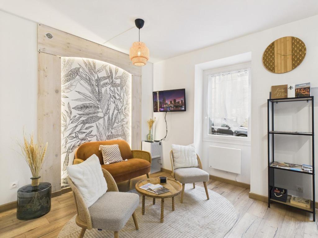 una sala de estar con un sofá y dos sillas en Jolie maison pour 4 à proximité du centre, en Montignac