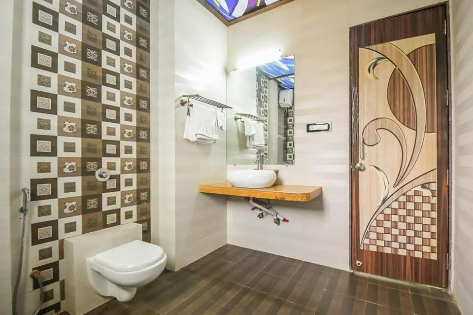 a bathroom with a toilet and a sink and a mirror at GA Bunglow 4Bhk Villa with pool in Lonavala