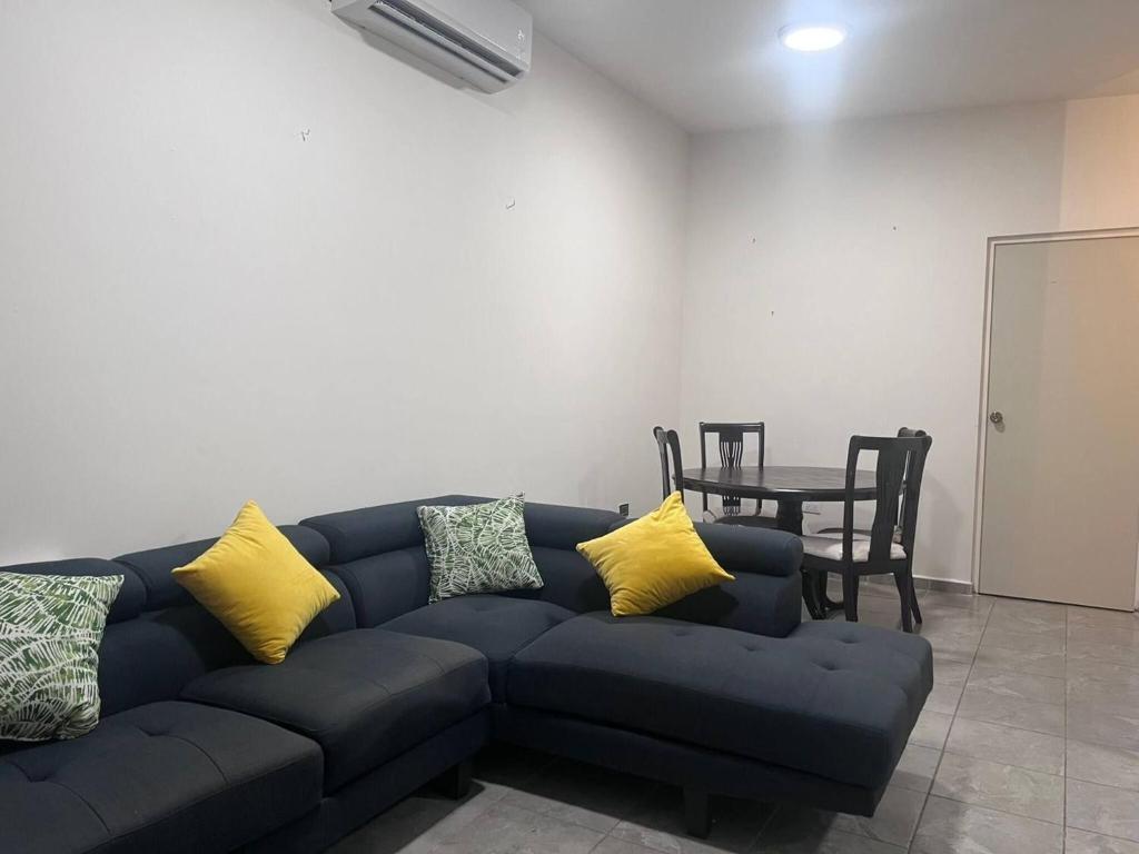 a living room with a blue couch with yellow pillows at Serene Retreat in Guaymas, Mexico - Your Home Away from Home in Colonia Miramar