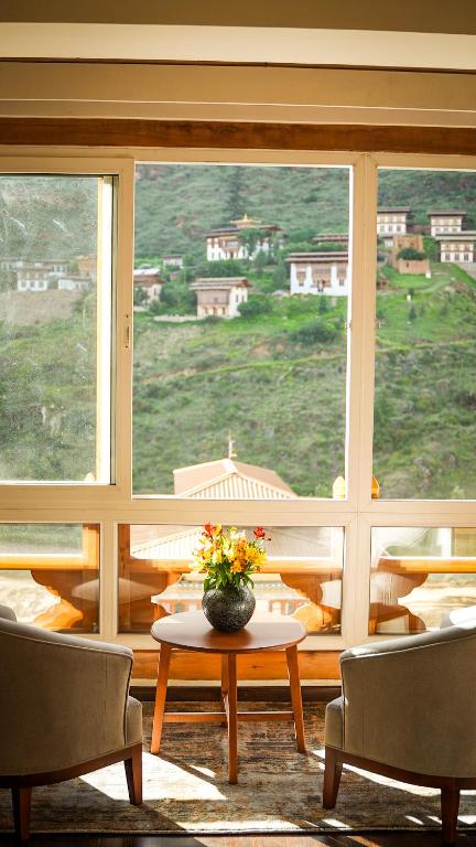 Habitación con mesa, 2 sillas y ventana en The 33rd Executive Suites, en Thimphu