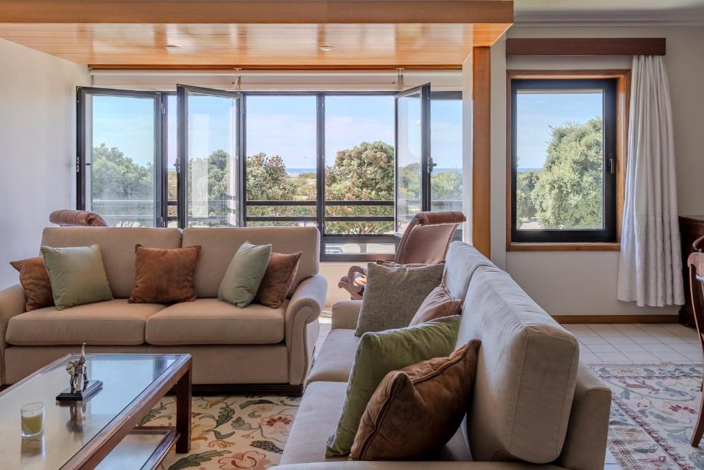 a living room with two couches and a table at Vista Atlântica-Vila do Conde in Vila do Conde