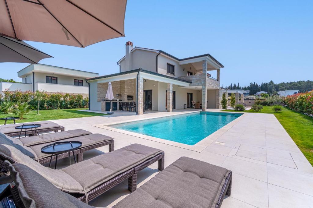 a villa with a swimming pool and a house at NEW! Luxury Villa Carlotte with 11m pool in Poreč