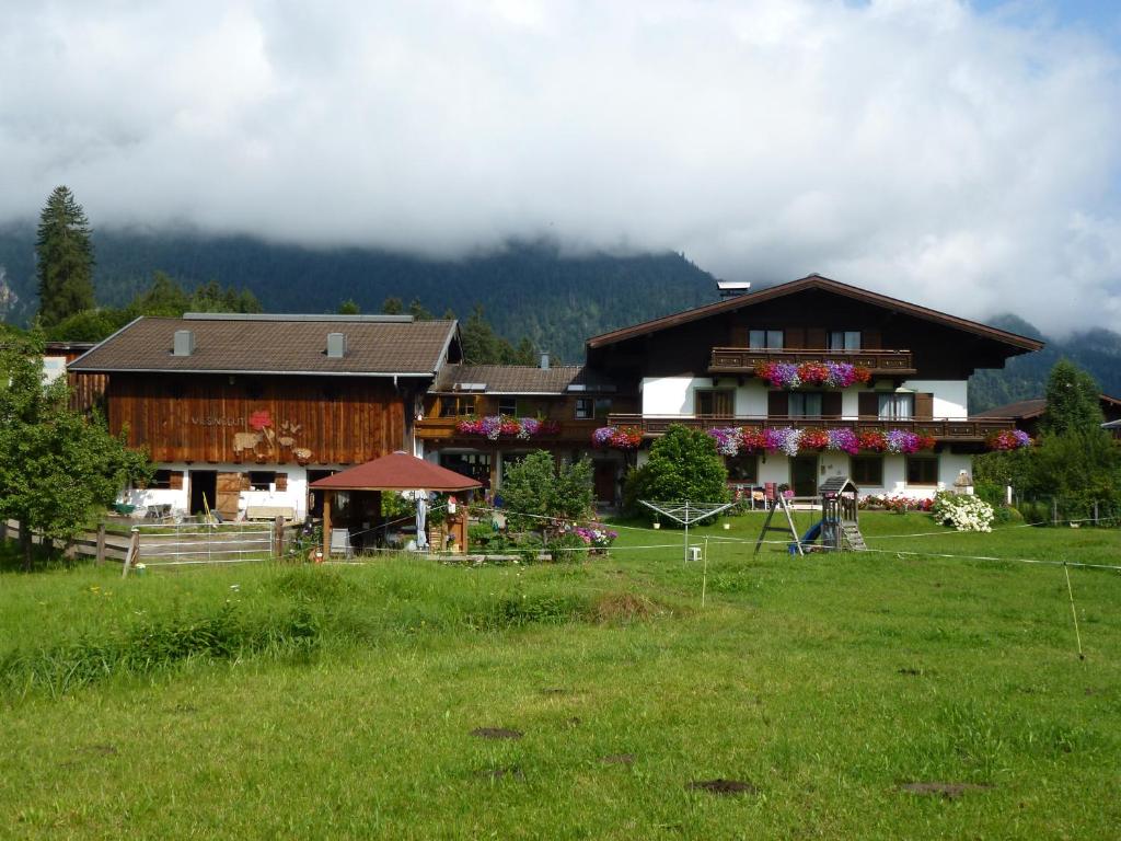 a large building in a field next to a mountain at Wiesingbauer in Saalfelden am Steinernen Meer