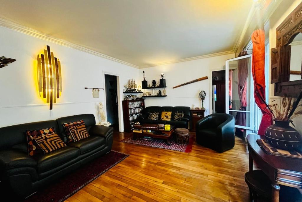 a living room with a couch and a table at 16th 10 minutes from the Eiffel Tower Metro line 9 in Paris