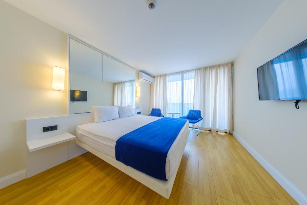 a hotel room with a bed and a tv at Orbi City Collection in Batumi