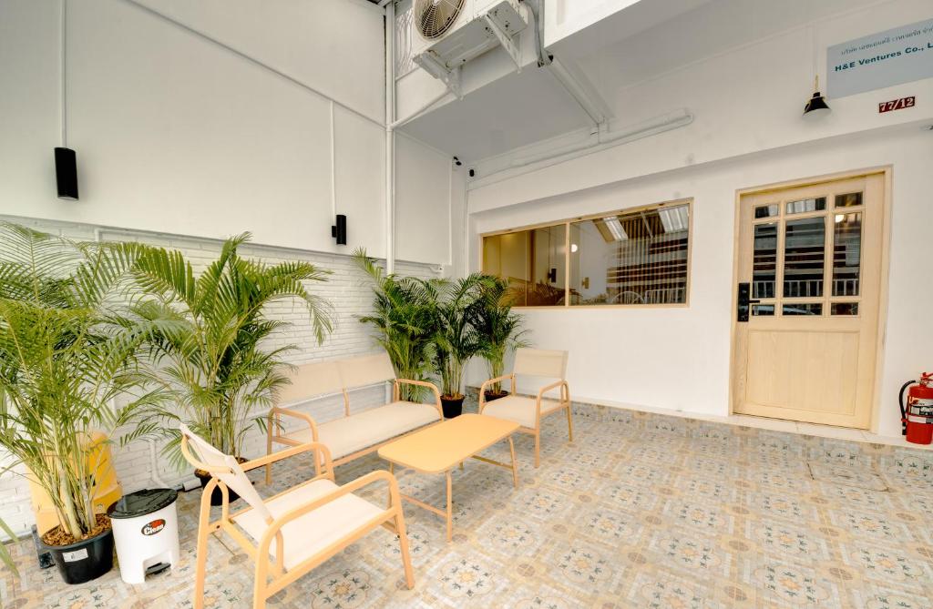 an empty room with chairs and plants in it at The Ostel Hostel Bangkok in Bangkok