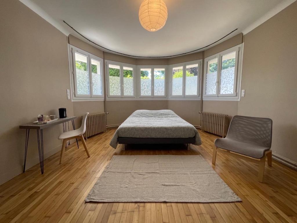 a bedroom with a bed and a table and a chair at Chambre cozy avec sdb privée à 7min de la gare in Redon