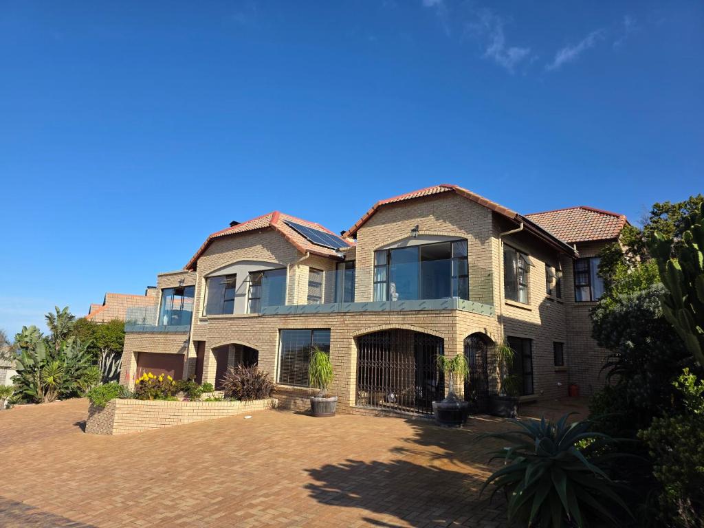 una casa grande con un patio de ladrillos en Golf & Tides Deluxe, en Mossel Bay