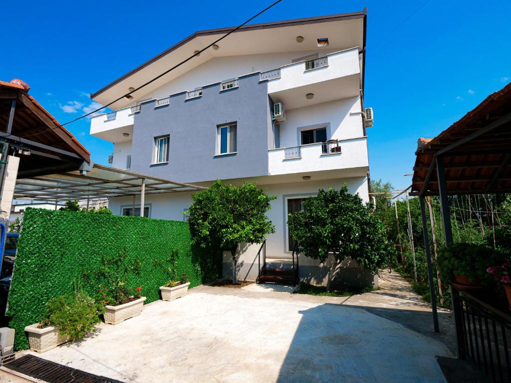 a white building with a hedge in front of it at Daydream Villas in Shkodër