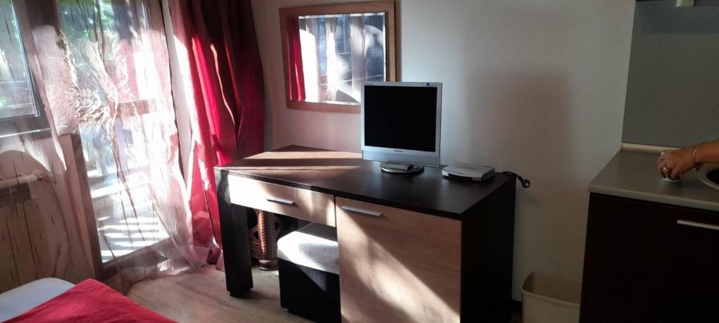 a desk with a computer monitor on top of it at Relax in Banyas Hidden Gem - Igzila appartment in Banya