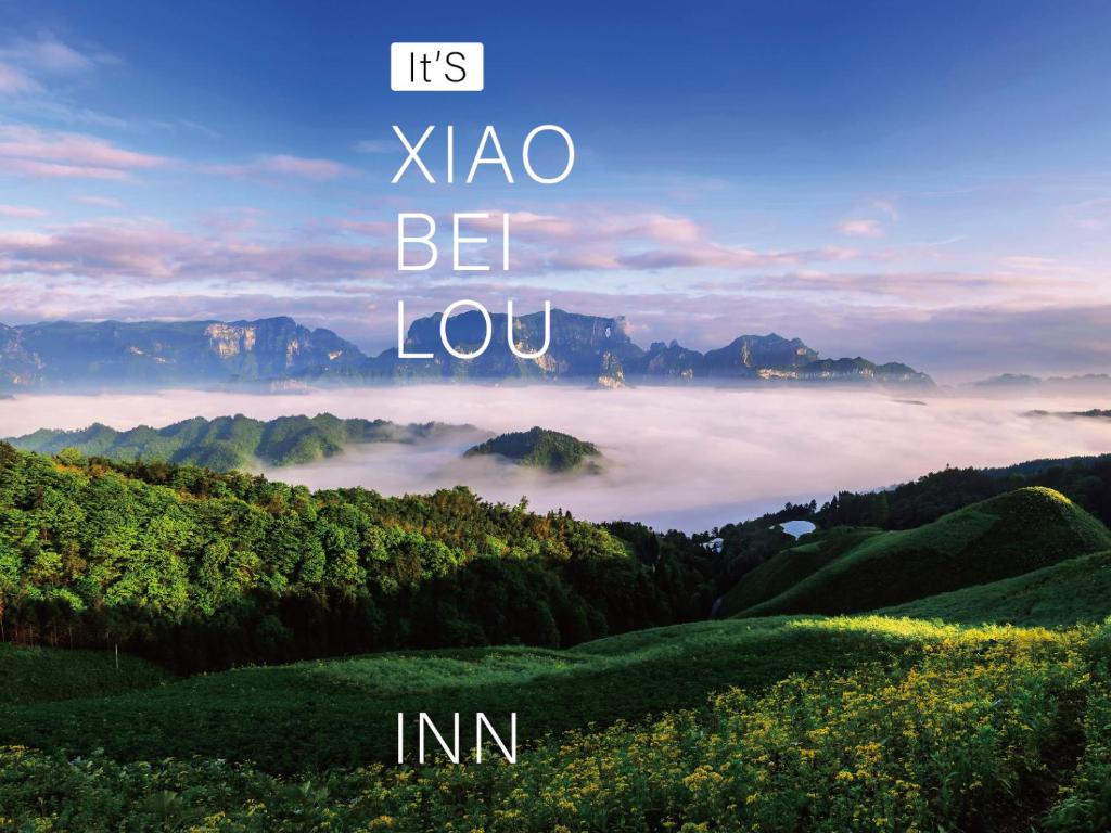 Una imagen de un valle con niebla en las montañas. en Xiaobeilou Inn Zhangjiajie Railway Station Tianmen Mountain Cableway Branch, en Zhangjiajie