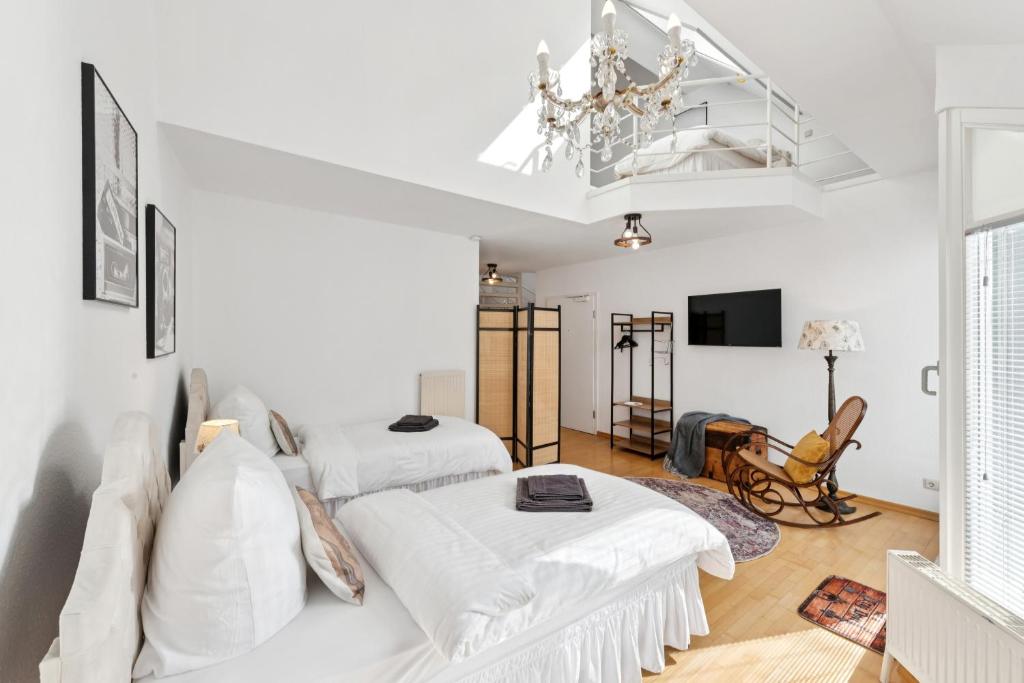 Cette chambre blanche dispose de 2 lits et d'un lustre. dans l'établissement "Gelbe Koffer Vintage Maisonette" in Neunkirchen - 2 SZ - Self-Check-in - Parkplatz - Balkon - Badewanne - WLAN 250 Mbit - bis 4 Pers - zentrumsnah, à Neunkirchen