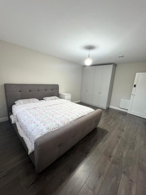 a bedroom with a large bed and wooden floors at Happy Place in Navan