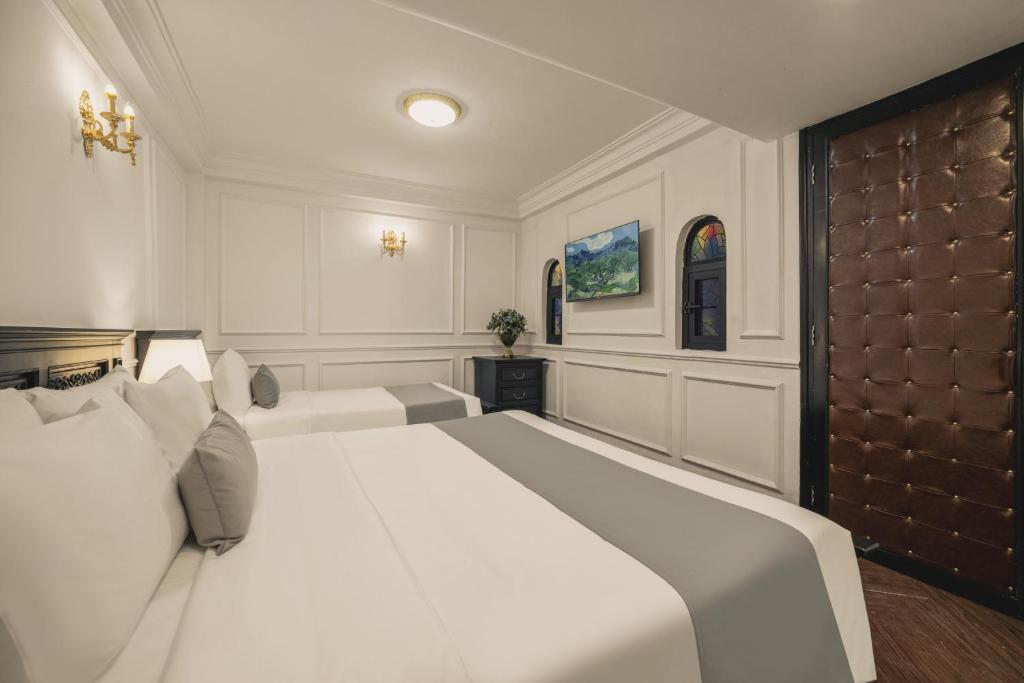 Phòng nghỉ tại Vina Vintage Hotel nổi bật với gam xanh cổ điển, sàn gỗ và đèn chùm, tạo không gian ấm cúng phù hợp cho cặp đôi hoặc khách nghỉ ngắn ngày tại Huế.