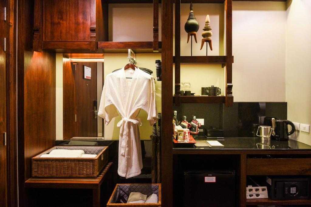 A compact hospitality kitchenette with a sink, drinks station, minibar and in-room safe.