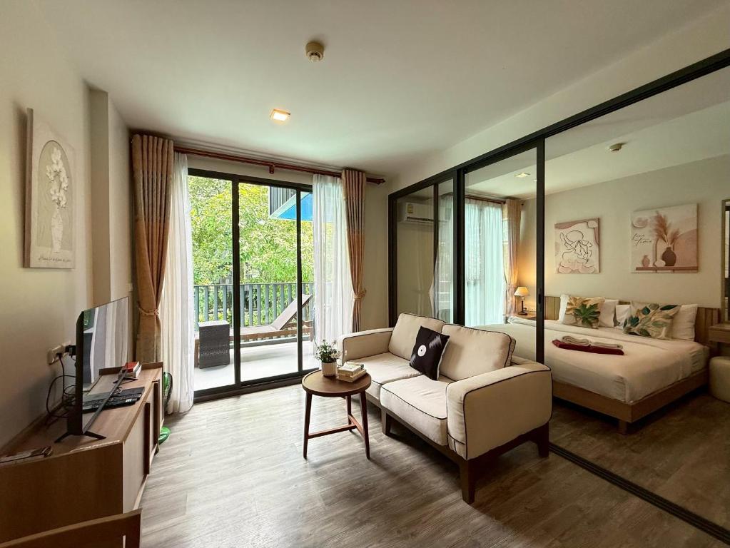 Una sala de estar con un sofá y un televisor. en The Deck Patong Phuket by Mickey, en Patong Beach