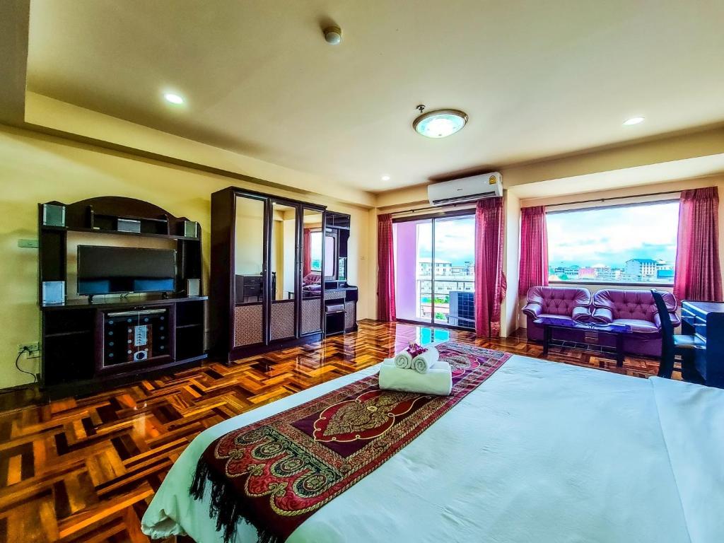 a bedroom with a bed and a tv and a couch at Yamadaya Apartment in Phra Nakhon Si Ayutthaya