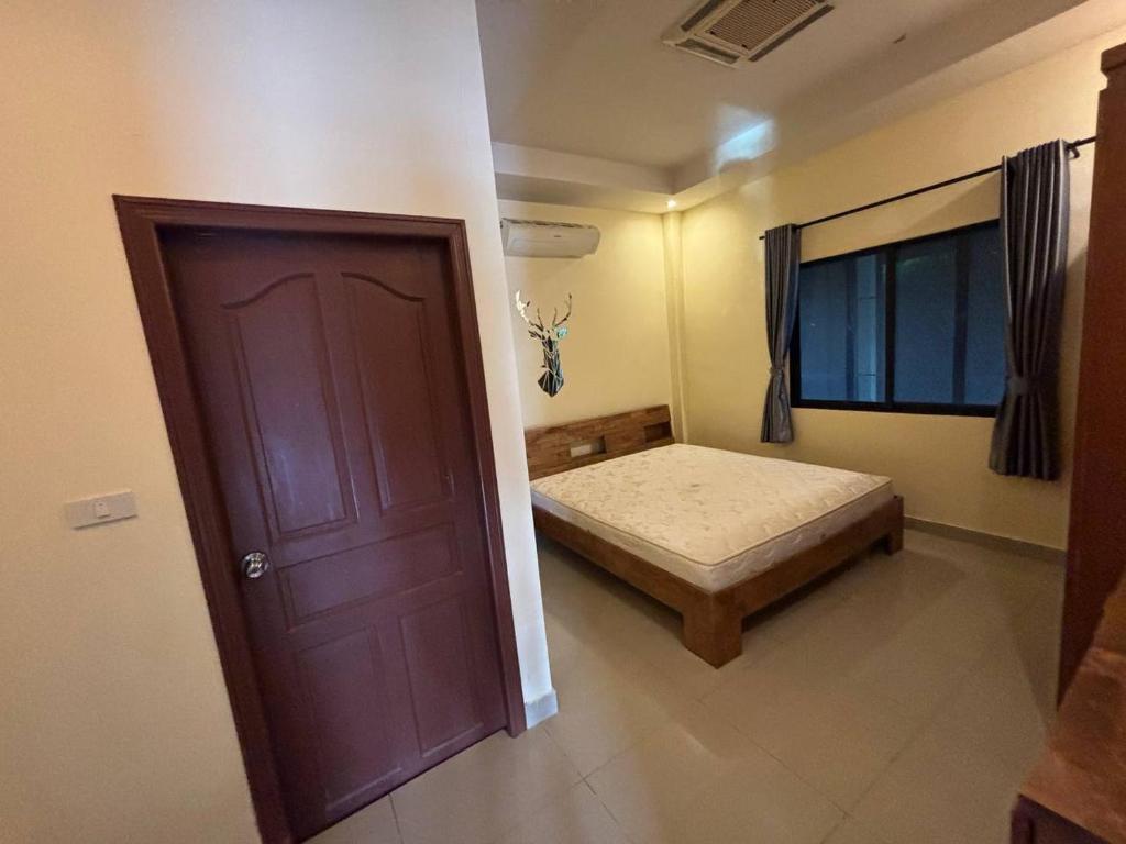 a bedroom with a bed and a door with a window at Unique Paradise Resort in Ban Map Fakthong