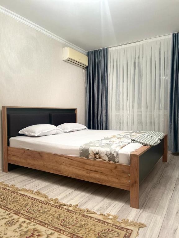 a bedroom with a large bed in front of a window at Посуточно квартира in Aktobe