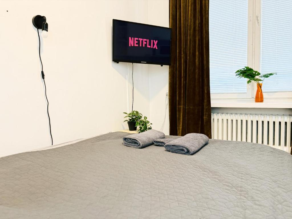 un letto con due cuscini sopra e una televisione di Nordstay - Nordic Central Flat with self check-in a Helsinki