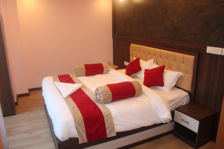a bedroom with two beds with red and white pillows at Hotel White Palace Airport Kathmandu in Pashupatināth