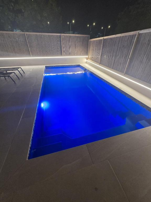 a swimming pool with blue water at night at Vila Lidar in Eilat